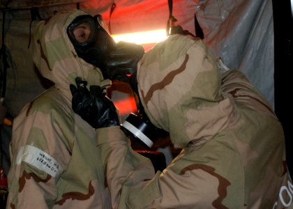 US Navy 090401-N-4973M-006 Yeoman 3rd Class Franco Velasquez, assigned to Amphibious Construction Battalion (ACB) 1, assists Storekeeper Seaman Monica Wright, also assigned to ACB-1, with her mission oriented protective posture