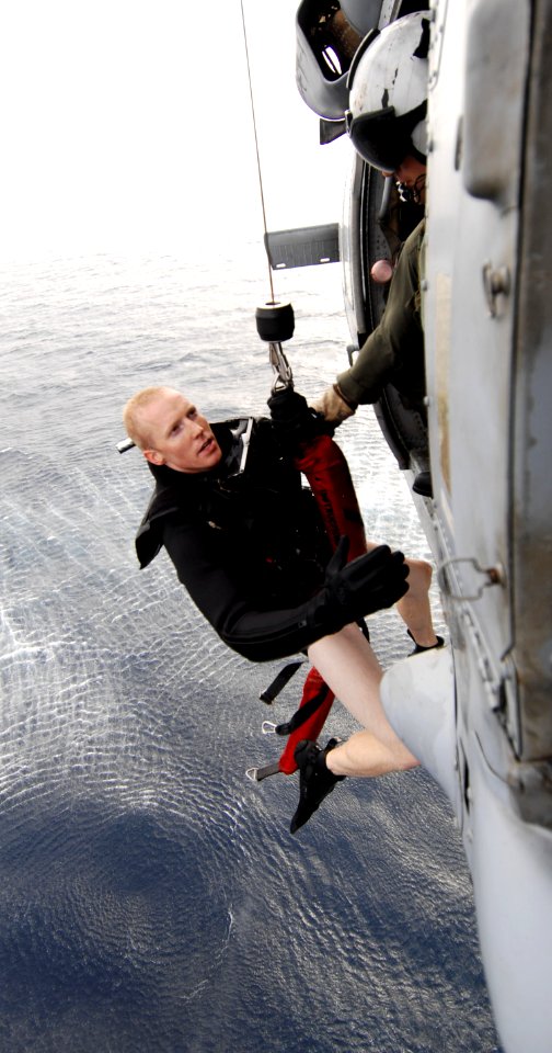 US Navy 090401-N-6639M-525 Naval Air Crewman 2nd Class Ryne Mueller, a search and rescue swimmer assigned to Helicopter Sea Combat (HSC) 21 Detachment 3, is pulled into a helicopter during a training mission