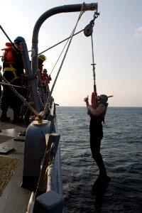 US Navy 090401-N-9123L-002 Search-and-Rescue Swimmer Gunner's Mate 2nd Class Antonio Rodriguez, from Los Angeles, signals he is ready to be lowered to line handlers