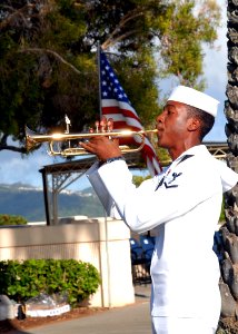 US Navy 090406-N-5476H-157 Musician 3rd Class Anthony Chiles plays Taps during a memorial ceremony photo