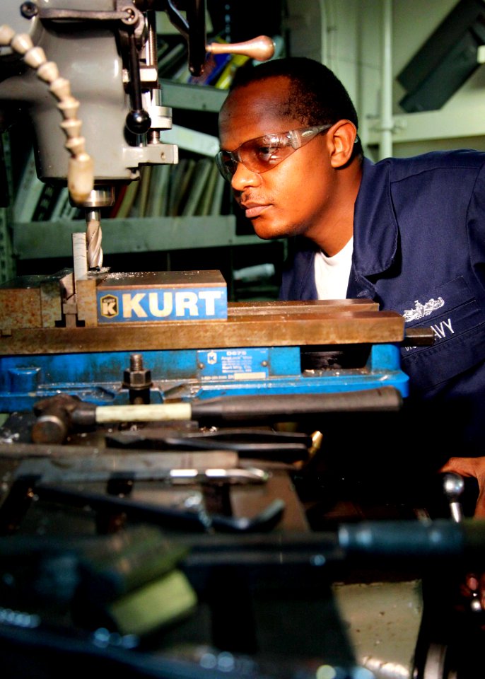 US Navy 090403-N-9150R-012 Machinery Repairman Fireman Siza Karlo machines a part for a specialty hinge