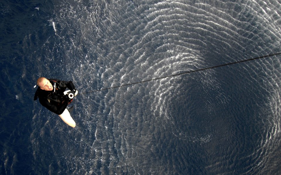 US Navy 090401-N-6639M-519 Naval Air Crewman 2nd Class Ryne Mueller, a search and rescue swimmer assigned to Helicopter Sea Combat (HSC) 21 Detachment 3, is pulled out of the water during a training mission