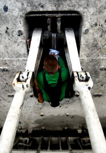 US Navy 090407-N-6538W-025 Aviation Boatswain's Mate Airman Oscar Auten, from Council Bluffs, Iowa, wipes down the hydraulic piston of a jet-blast deflector on the flight deck of the Nimitz-class aircraft carrier USS John C. St