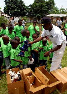 US Navy 090403-N-1655H-204 Cameroon Armed Forces Navy Lt. Cmdr. Clement Fru Fon of Africa Partnership Station Nashville gives stuffed animals to children at the Save the Children Alliance Orphanage