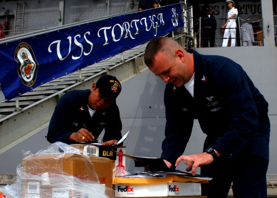 US Navy 090407-N-6692A-008 Storekeeper 2nd Class Jeffrey Jose, from New Orleans, and Storekeeper 2nd Class Richard Young from, St. Louis, work on supply requisitions for the amphibious dock landing ship USS Tortuga (LSD 46)