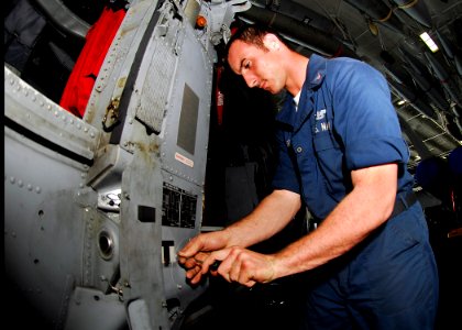 US Navy 090413-N-0096C-011 Aviation Structural Mechanic 3rd Class Marcus McElroy, from Houma, La., performs maintenance on the stub wing panel of an MH-60S Sea Hawk helicopter