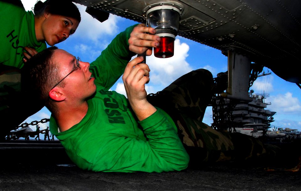 US Navy 090404-N-6597H-058 Aviation Electrician's Mate 2nd Class Alan Pollard, right, from San Diego, and Aviation Electrician's Mate Airman Ashley Westcott, from Oceanside, Calif., perform preventive maintenance