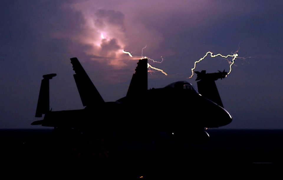 US Navy 090408-N-2610F-293 Lightning strikes behind an F-A-18C Hornet from the