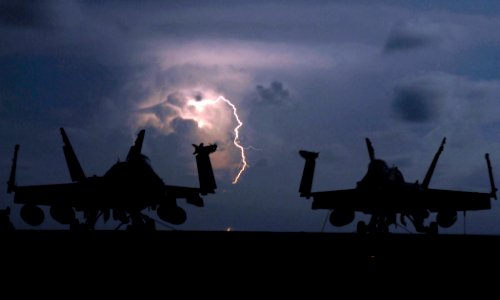 US Navy 090408-N-2610F-340 Lightning strikes behind two F-A-18C Hornet strike fighters from the