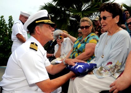 US Navy 090408-N-9758L-087 Capt. Douglas Waite, command chaplain for commander, Navy Region Hawaii and Naval Surface Group Middle Pacific, hands a folded American flag to the wife of Pearl Harbor survivor retired Capt. Demetriu photo