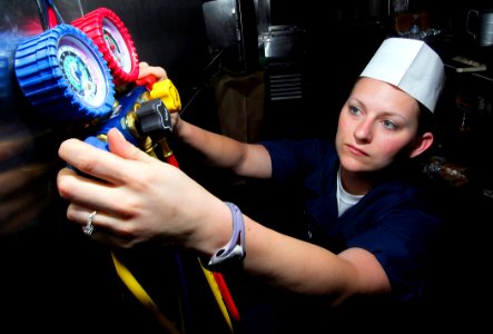 US Navy 090414-N-6597H-058 Machinist Mate Fireman Katherine Mitchon, from Huntington, Texas, pressure checks and recharges a refrigerator condenser unit in the wardroom aboard the Nimitz-class aircraft carrier USS John C. Stenn