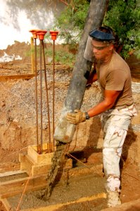 US Navy 090411-N-1057H-036 Builder 2nd Class Brian Monroe, assigned to Naval Mobile Construction Battalion (NMCB) 11, Detachment Horn of Africa, pours concrete photo