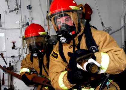US Navy 090411-N-5215E-014 Damage Controlman Fireman Apprentice Jeff Kingree and Damage Controlman 3rd Class Kevin Martinez prepare to combat a simulated fire during a damage control drill photo