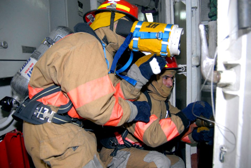 US Navy 090408-N-6552M-048 Damage Controlman Fireman Jacob Hendrickson and Intelligence Specialist 3rd Class Benny Salazar practice fire fighting during damage control training aboard the amphibious assault ship USS Boxer (LHD