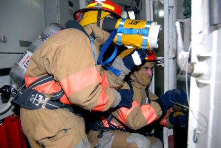 US Navy 090408-N-6552M-048 Damage Controlman Fireman Jacob Hendrickson and Intelligence Specialist 3rd Class Benny Salazar practice fire fighting during damage control training aboard the amphibious assault ship USS Boxer (LHD