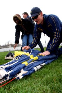 US Navy 090407-N-5366K-047 Chief Special Warfare Operator (SEAL) William Davis, assigned to the Navy demonstration parachute team the Leap Frogs, shows students at Whitehall High School how to pack his parachute photo