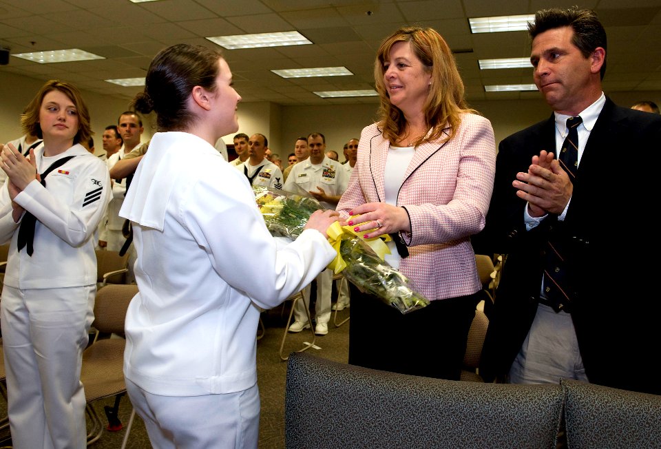 US Navy 090415-N-5319A-008 Mass Communication Specialist Seaman Kathleen O'Keefe hands flowers to Katherine McRill, widow of Mass Communication Specialist 1st Class Bobby McRill, during a graduation ceremony at Defense Informat