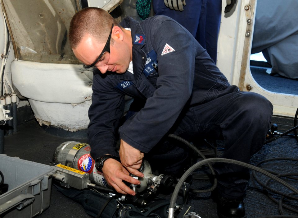US Navy 090416-N-3666S-052 Hull Maintenance Technician 1st Class Bryan Silva refills a self-contained breathing apparatus