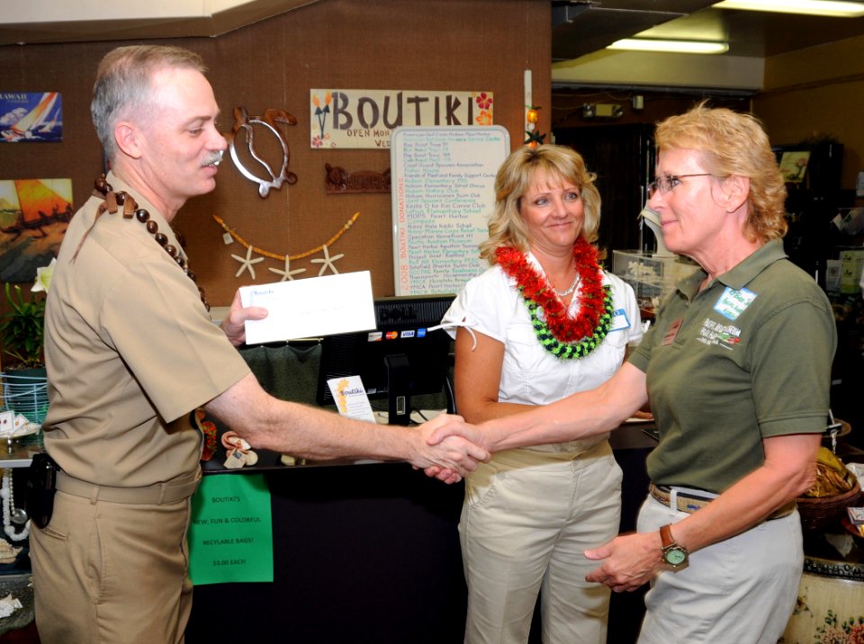 US Navy 090413-N-3666S-018 Capt. Richard Kitchens and Julie Smithpresent KT Budde-Jones with a check during a donation ceremony at the Boutiki Gift Shop at Naval Station Pearl Harbor