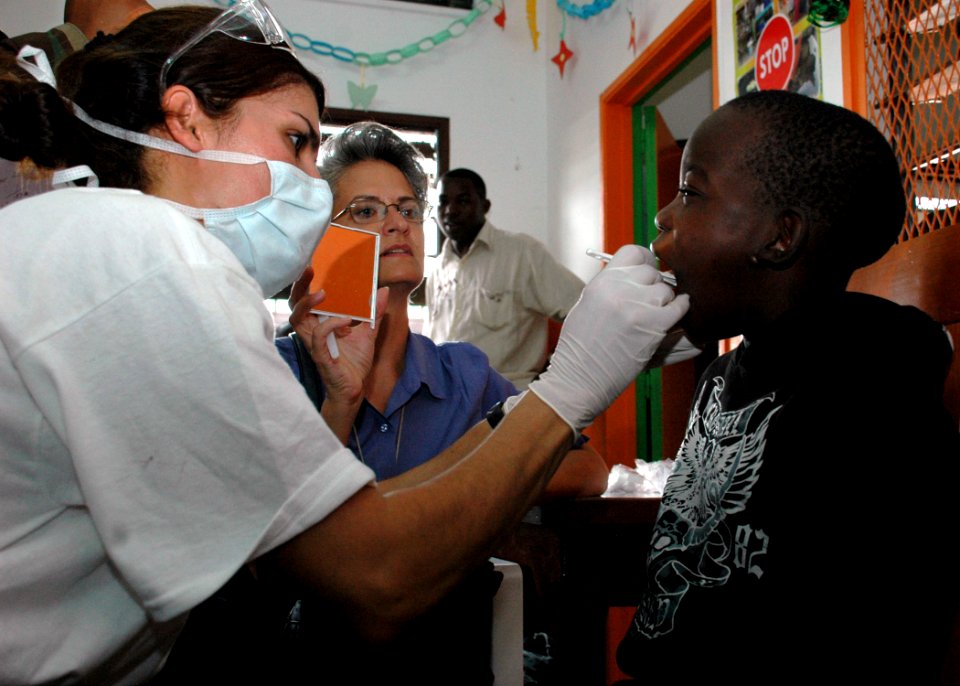 US Navy 090416-N-1655H-109 Lt. Cmdr. Shay Ramzi, a dentist with the Africa Partnership Station Nashville Department of Defense dental team, gives an oral exam to a child at the Centre Arc-en-Ciel children's shelter