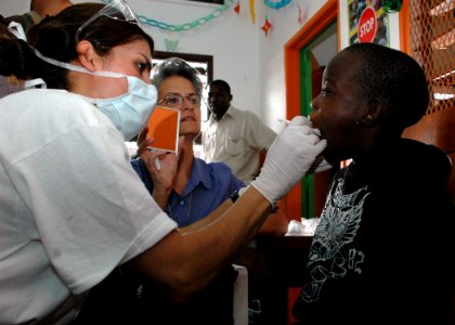 US Navy 090416-N-1655H-109 Lt. Cmdr. Shay Ramzi, a dentist with the Africa Partnership Station Nashville Department of Defense dental team, gives an oral exam to a child at the Centre Arc-en-Ciel children's shelter
