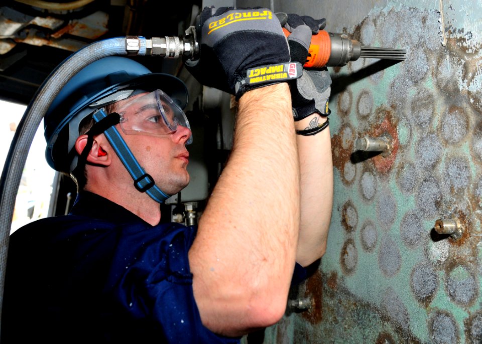 US Navy 090415-N-2013O-017 Operations Specialist 1st Class Gary Yarbrough, from Springville, Ala., uses a needle gun to chip paint off a bulkhead aboard the Arleigh Burke-class guided-missile destroyer USS Lassen (DDG 82)