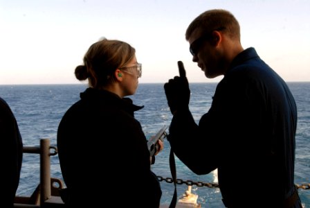 US Navy 090417-N-2344B-145 Gunner's Mate Seaman Andrew P. Just instructs Gunner's Mate Seaman Mary Pountney in correct procedure during a live fire exercise on the fantail of the aircraft carrier USS Ronald Reagan (CVN 76)