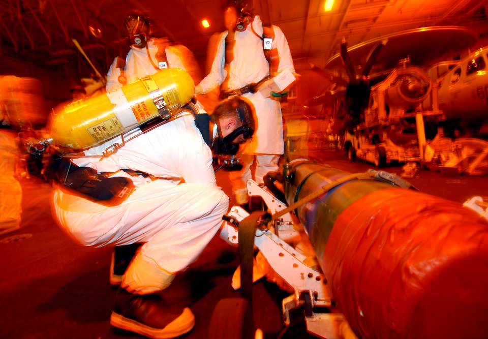 US Navy 090415-N-6597H-077 Aviation Ordnanceman 3rd Class David Kopp, from Killeen, Texas, cleans a simulated Otto II fuel spill as part of the primary response team during a general quarters drill in the hangar bay aboard the
