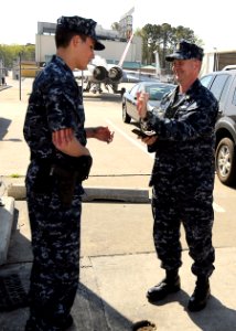 US Navy 090417-N-4515N-002 Aviation Ordnanceman Airman Christopher Kresini checks the identification of Master Chief Petty Officer of the Navy (MCPON) Rick West before allowing West to enter Naval Air Station Oceana photo