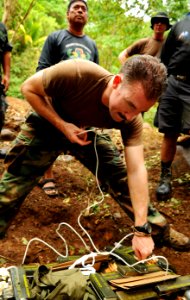 US Navy 090418-N-7130B-092 Explosive Ordnance Disposal Technician 2nd Class Travis Becker, assigned to the Joint Special Operations Task Force-Philippines Explosive Ordnance Disposal Task Unit, uses a booster cord to provide co photo