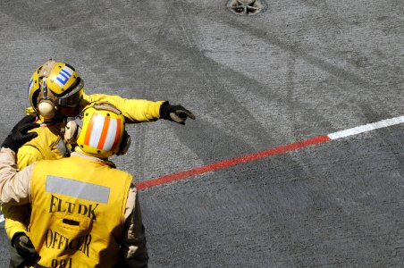 US Navy 090417-N-3659B-046 Lt. Ivan Borja, flight deck officer aboard the aircraft carrier USS Ronald Reagan (CVN 76), advises an aviation boatswain's mate (Handling) on ways to improve his technique for directing aircraft on t