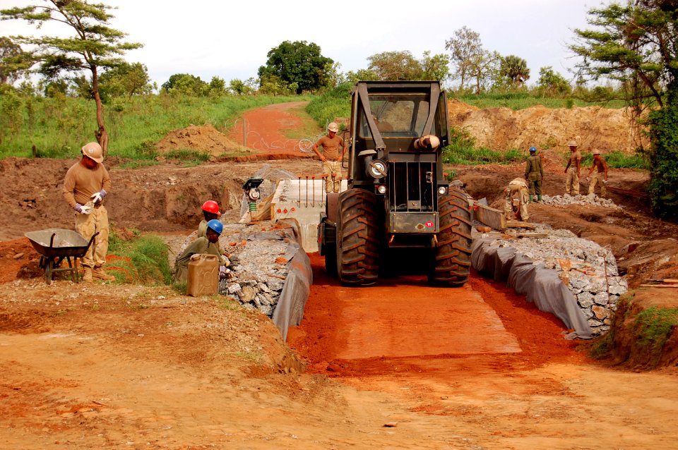 US Navy 090418-N-1057H-037 Sailors assigned to Naval Mobile Construction Battalion (NMCB) 11, Detachment Horn of Africa and members of the Ugandan People's Defense Force build the Welela low-water crossing bridge