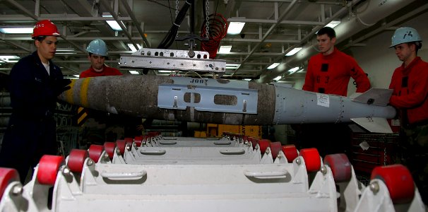 US Navy 090418-N-6597H-106 Aviation Ordnancemen use a hydraulic lift to work on a 1,000 pound joint direct attack munitions guided bomb unit in the main bomb assembly shop aboard the aircraft carrier USS John C. Stennis (CVN 74