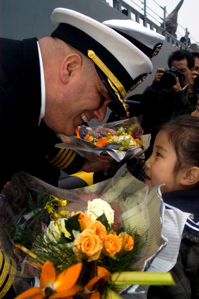 US Navy 090419-N-1251W-112 Cmdr. Richard Dromerhauser, commanding officer of the USS Fitzgerald (DDG 62), receives a bouquet of flowers from a child after Fitzgerald's arrival in the port city of Qingdao