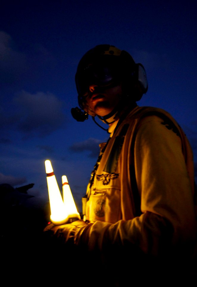 US Navy 090418-N-6538W-247 Aviation Boatswain's Mate (Handling) Airman Richard Koller, from Baltimore, directs aircraft on the flight deck during night flight operations aboard the aircraft carrier USS John C. Stennis (CVN 74)