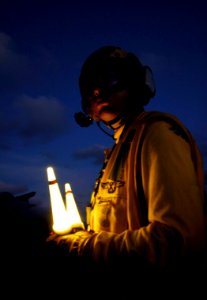 US Navy 090418-N-6538W-247 Aviation Boatswain's Mate (Handling) Airman Richard Koller, from Baltimore, directs aircraft on the flight deck during night flight operations aboard the aircraft carrier USS John C. Stennis (CVN 74)