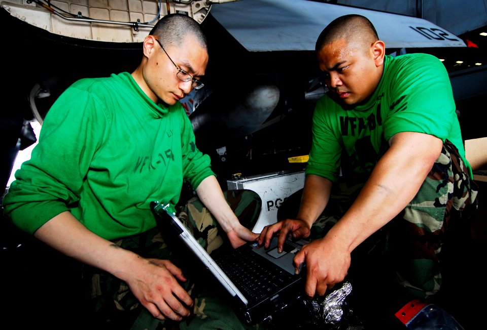 US Navy 090421-N-6538W-069 Aviation Structural Mechanic (Equipment) 2nd Class Erik Gratil, right, and Aviation Structural Mechanic Airman Yijia Liu, perform maintenance on an F-A-18F Super Hornet from the