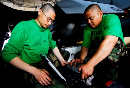 US Navy 090421-N-6538W-069 Aviation Structural Mechanic (Equipment) 2nd Class Erik Gratil, right, and Aviation Structural Mechanic Airman Yijia Liu, perform maintenance on an F-A-18F Super Hornet from the