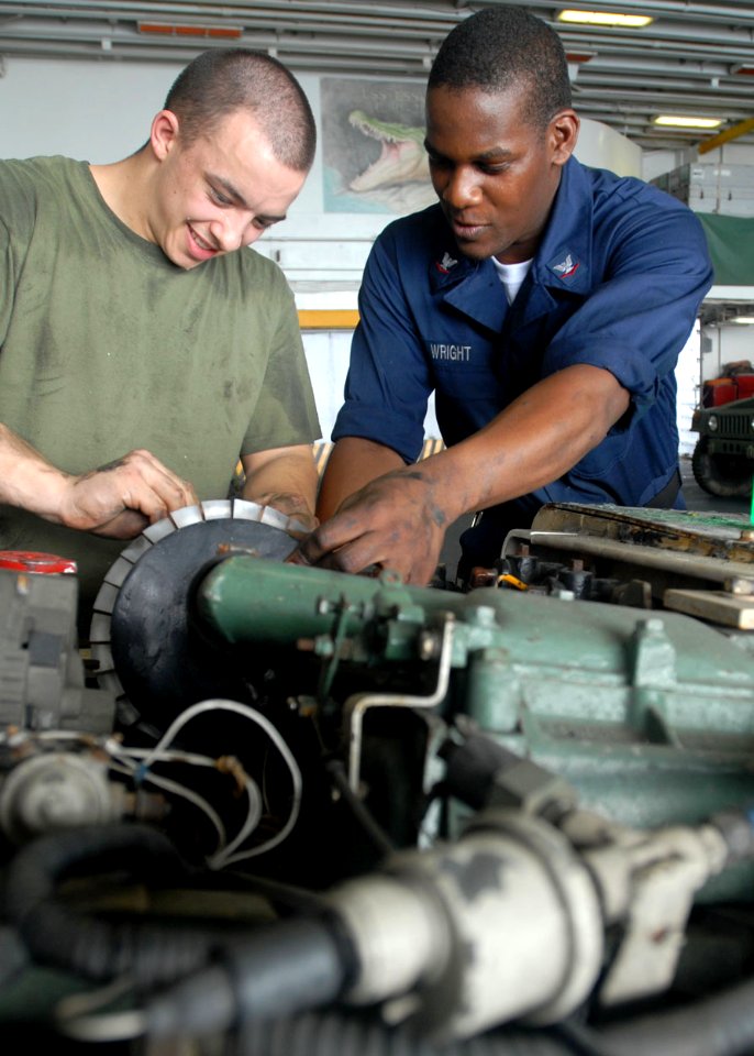 US Navy 090420-N-9950J-066 Marine Private 1st Class Joshua Huitt, from Houston, and Aviation Support Equipment Technician 3rd Class Justin Wright, from Chicago, replace the filter on a tractor