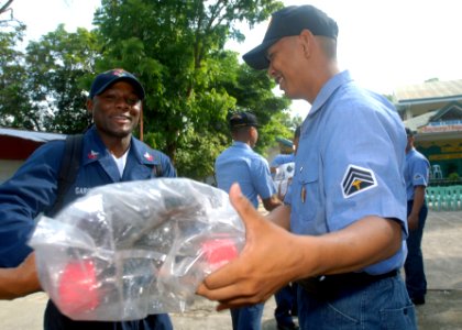 US Navy 090418-N-9950J-236 Postal Clerk 1st Class Brian Garfield, assigned to the amphibious assault ship USS Essex (LHD 2), works with Philippine sailors to move supplies at Barretto National High School during a community ser