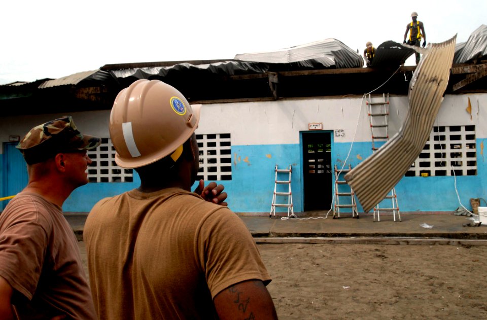 US Navy 090421-N-7948C-041 Construction Electrician 2nd Class Darius Michael assigned to Naval Mobile Construction Battalion (NMCB) 11 removes a piece of aluminum from the top of Balise Elementary School in Port Gentil