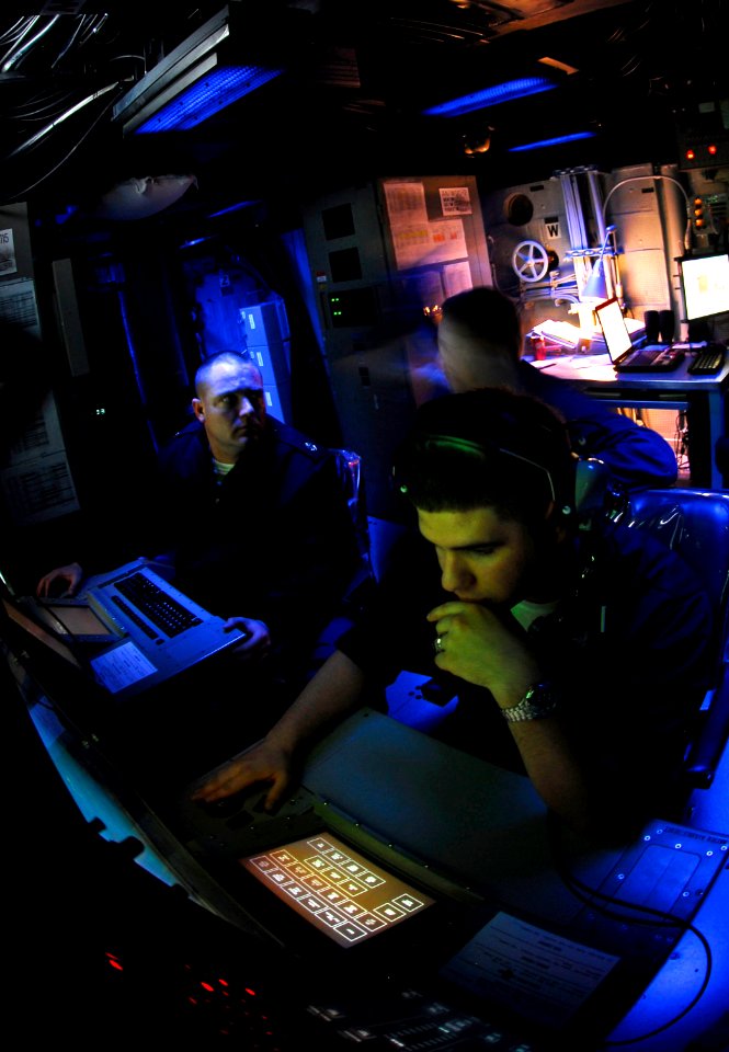 US Navy 090420-N-9928E-233 Sonar Technicians (Surface) track and report simulated mines during an under-sea warfare training scenario in the sonar room aboard the Arleigh Burke-class guided-missile destroyer USS Kidd (DDG 100)