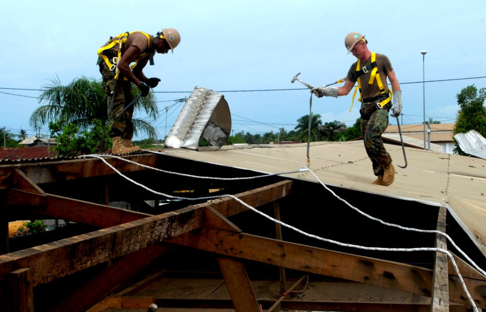 US Navy 090421-N-7948C-054 Construction Electrician 2nd Class Darius Michael, left, and Builder 2nd Class Patrick Tansey pull out nails from the roof of Balise Elementary School in Port Gentil