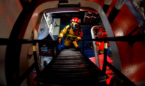 US Navy 090422-N-9928E-292 Seaman Eric Arroyo, from Las Cruces, N.M., searches for battle damage and hot spots during a fire drill aboard the Arleigh Burke-class guided-missile destroyer USS Kidd (DDG 100) photo