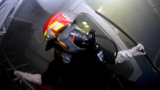 US Navy 090422-N-9928E-072 Information Systems Technician Seaman Apprentice Fernando Dominguez, from Riverside, Calif., carries a rake to overhaul a simulated class alpha fire