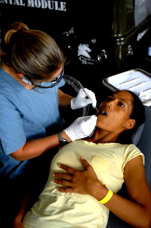US Navy 090423-F-7923S-021 Linzey File, a UCLA pre-dental student and dental hygienist embarked aboard the Military Sealift Command hospital ship USNS Comfort (T-AH 20), performs a cleaning on Maria Reyes during a Continuing Pr