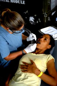 US Navy 090423-F-7923S-021 Linzey File, a UCLA pre-dental student and dental hygienist embarked aboard the Military Sealift Command hospital ship USNS Comfort (T-AH 20), performs a cleaning on Maria Reyes during a Continuing Pr