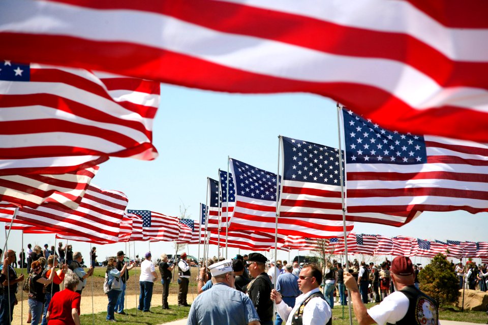 US Navy 090424-N-3271W-021 More than 500 veterans who escorted the unclaimed remains of seven Iowa veterans to their final resting place at the Iowa Veterans Cemetery line the procession route with American flags after providin