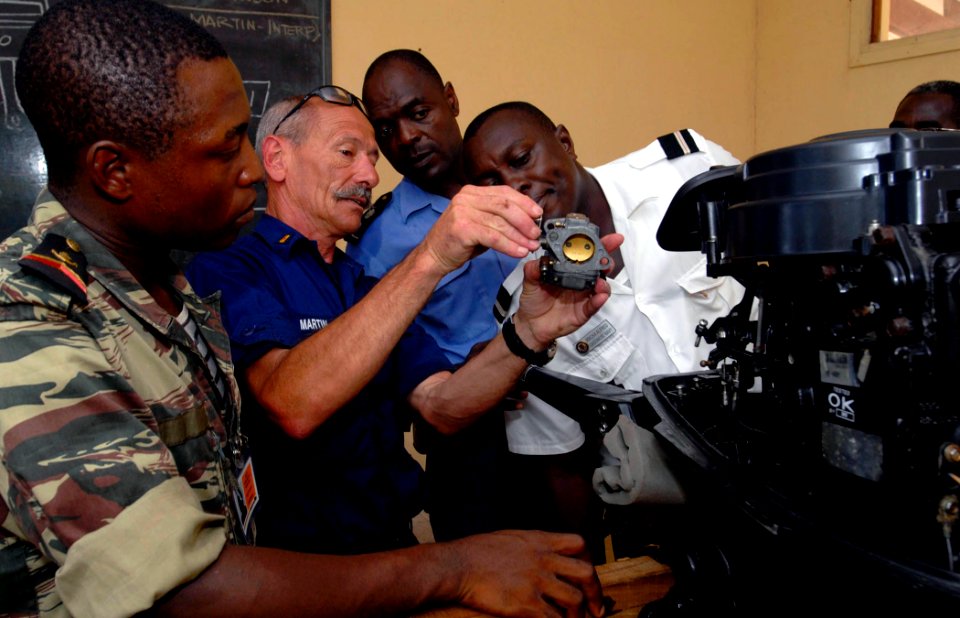 US Navy 090422-N-7948C-131 U.S. Coast Guard Auxiliary Warrant Officer Rene Martin discusses proper boat maintenance with Gabon military members aboard the amphibious transport dock ship USS Nashville (LPD 13)