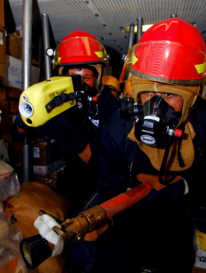 US Navy 090422-N-4047W-054 Damage Controlman Fireman David Garcia uses a Navy Infrared Thermal Imager to direct nozzleman Damage Controlman Fireman Raul Avila towards a simulated class alpha fire